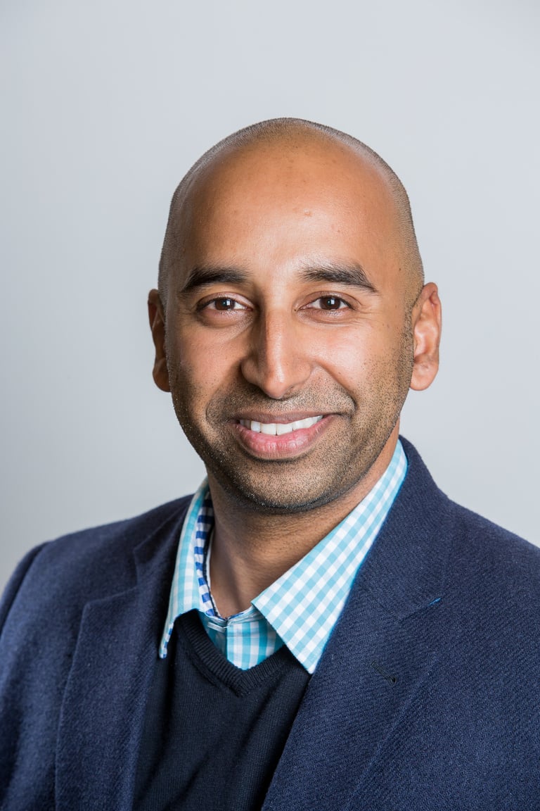 an individual in a suit and tie smiling for the camera